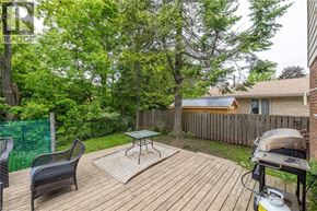 Owen Sound apartment for rent - A backyard with a wooden deck, a grill, and a green fence.