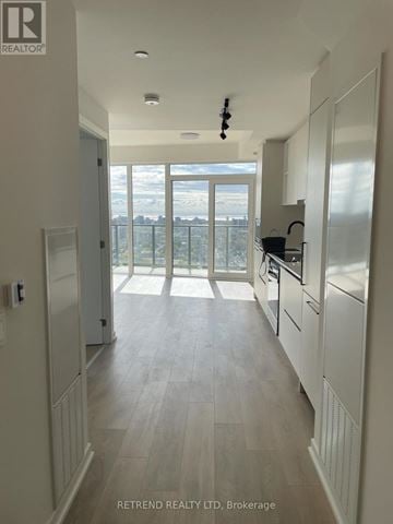 Toronto (Dovercourt-Wallace Emerson-Junction) condo for rent - A kitchen with white cabinets and a view of the city.