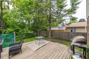 Owen Sound apartment for rent - A backyard with a wooden deck, a grill, and a green fence.