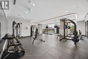 Oshawa (Windfields) condo for rent - A gym with a variety of equipment including dumbbells, weight plates, and a squat rack.