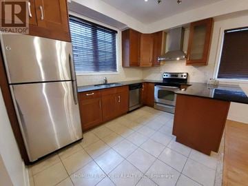 Richmond Hill (Langstaff) townhouse for rent - A kitchen with a refrigerator, stove, and cabinets.