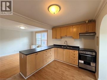 Hamilton apartment for rent - A kitchen with wooden cabinets and black countertops.