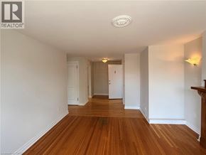 Hamilton apartment for rent - A long hallway with wood floors and white walls.