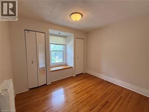 Hamilton apartment for rent - A room with wood flooring and a window with blinds.
