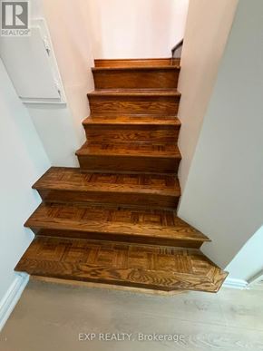 Toronto (Runnymede-Bloor West Village) apartment for rent - A set of wooden stairs with a white wall on the side.