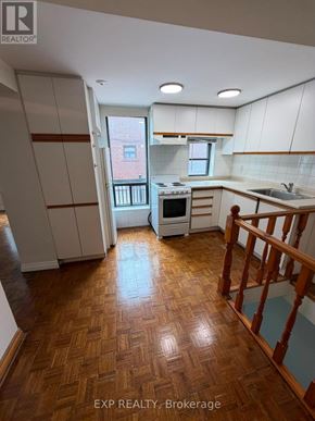 Toronto (Runnymede-Bloor West Village) apartment for rent - A kitchen with wooden floors and white cabinets.