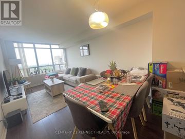 Toronto (Willowdale East) condo for rent - A living room with a couch, a coffee table, and a dining table with a plaid tablecloth.