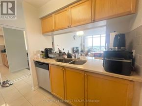 Toronto (Willowdale East) condo for rent - A kitchen with wooden cabinets and a white countertop.