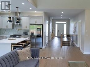 Fort Erie (Crescent Park) apartment for rent - A modern kitchen with a dining table and a grey couch.