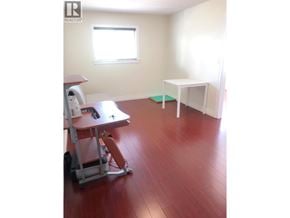 Burnaby apartment for rent - A room with a wooden floor and a white chair with wheels.