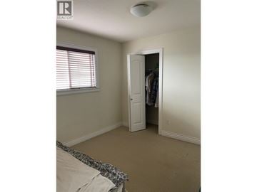 Burnaby apartment for rent - A bedroom with a bed and a closet.