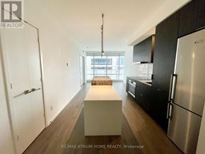 Toronto (Church-Yonge Corridor) condo for rent - A modern kitchen with a long white island in the middle.