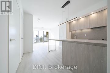 Toronto (Waterfront Communities) condo for rent - A modern kitchen with white cabinets and a countertop.