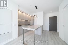 Toronto (Waterfront Communities) condo for rent - A modern kitchen with a table and a refrigerator.