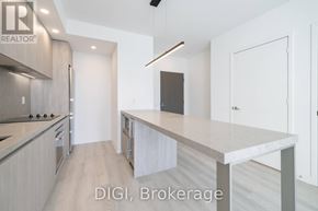 Toronto (Waterfront Communities) condo for rent - A modern kitchen with a large island in the middle.