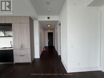 Toronto (Waterfront Communities) condo for rent - A long hallway with a kitchen area on the left and a door at the end.