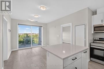 Oakville (Go Glenorchy) condo for rent - A spacious kitchen with white cabinets and a large island.