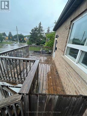 Kitchener apartment for rent - A wooden deck with a railing and a window is shown in the image.