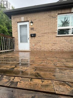 Kitchener apartment for rent - A wet wooden deck in front of a brick house.