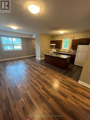 Kitchener apartment for rent - A kitchen with a refrigerator, sink, and cabinets.