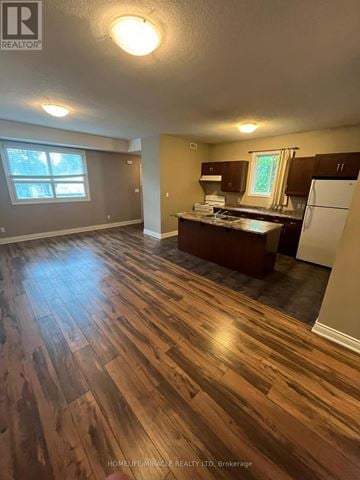 Kitchener apartment for rent - A kitchen with a refrigerator, sink, and cabinets.