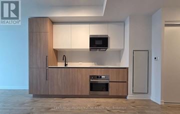 Toronto (Waterfront Communities) condo for rent - A modern kitchen with wooden cabinets and appliances.