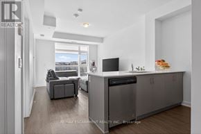 Hamilton (Lakeshore) condo for rent - A modern kitchen with a dishwasher and a refrigerator.