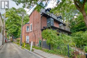 Toronto (Cabbagetown-South St. James Town) apartment for rent - A red brick house with a black fence in front of it.