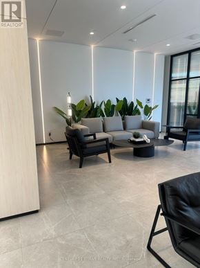 Toronto (Bayview Village) condo for rent - A modern waiting area with a wooden reception desk and comfortable seating.