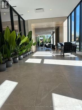 Toronto (Bayview Village) condo for rent - A hallway with a plant on the left and a chair on the right.