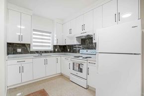 Surrey apartment for rent - A kitchen with white appliances and cabinets.