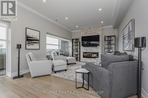 Guelph (Pineridge/Westminster Woods) condo for rent - A living room with a grey couch, a white chair, and a fireplace.