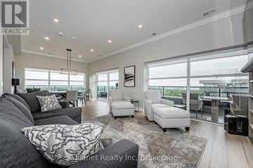 Guelph (Pineridge/Westminster Woods) condo for rent - A living room with a grey couch and a white chair.
