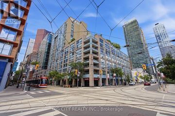 Toronto (Church-Yonge Corridor) condo for rent - A street view of a city with a realtor sign in the foreground.
