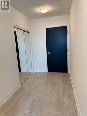 Oshawa (Windfields) condo for rent - A hallway with a black door and a white door with a mirror on the wall.