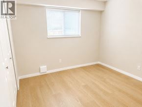 Burnaby apartment for rent - A room with light wood flooring and a window with blinds.