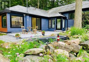 Innisfil apartment for rent - A blue house with a patio and a fire pit.