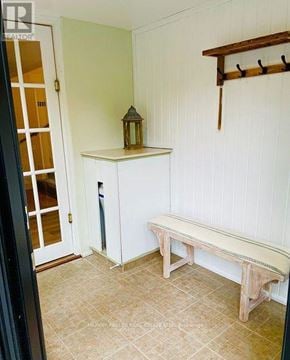Innisfil apartment for rent - A wooden bench sits in a room with white walls.