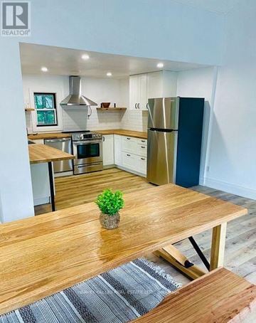 Innisfil apartment for rent - A modern kitchen with a wooden table and a plant on it.