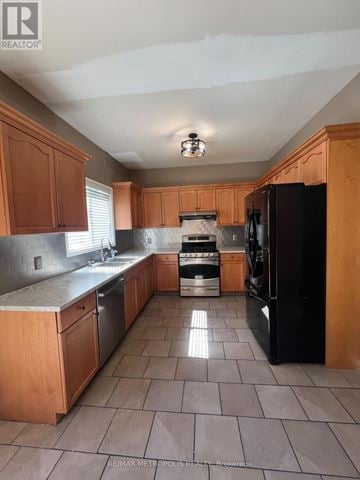 London North (North M) apartment for rent - A kitchen with wooden cabinets and a black refrigerator.