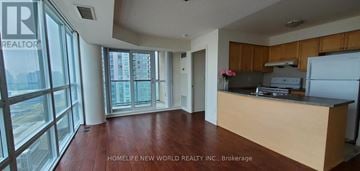 Toronto (Bendale) condo for rent - A kitchen with wooden floors and a counter with a refrigerator.