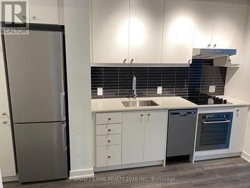 Toronto (Niagara) condo for rent - A kitchen with a refrigerator, sink, and oven.