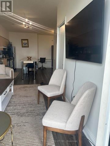 Toronto (Bayview Village) condo for rent - Two chairs are placed in a living room with a television mounted on the wall.