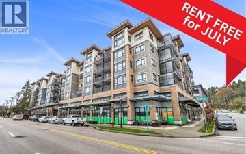Port Moody apartment for rent - A large building with a sign offering free rent for July.