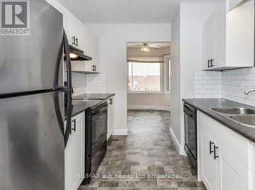 Woodstock (Woodstock - North) townhouse for rent - A modern kitchen with a stainless steel refrigerator and black countertops.