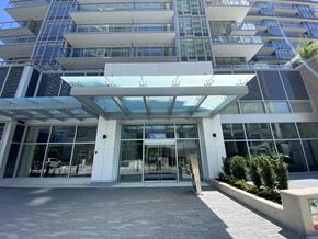 Surrey apartment for rent - The image shows a modern building with a glass facade and a white entrance with a glass door.