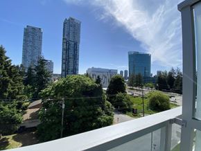 Surrey apartment for rent - A view from a balcony overlooking a cityscape with tall buildings and greenery.