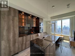Toronto (Annex) condo for rent - A modern kitchen with a marble countertop and a view of the city.