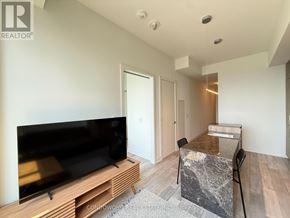 Toronto (Annex) condo for rent - A modern living room with a flat screen TV and a marble table.