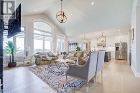 Kawartha Lakes (Manvers) apartment for rent - A well-lit, spacious living room with a grey sofa set and a large rug.